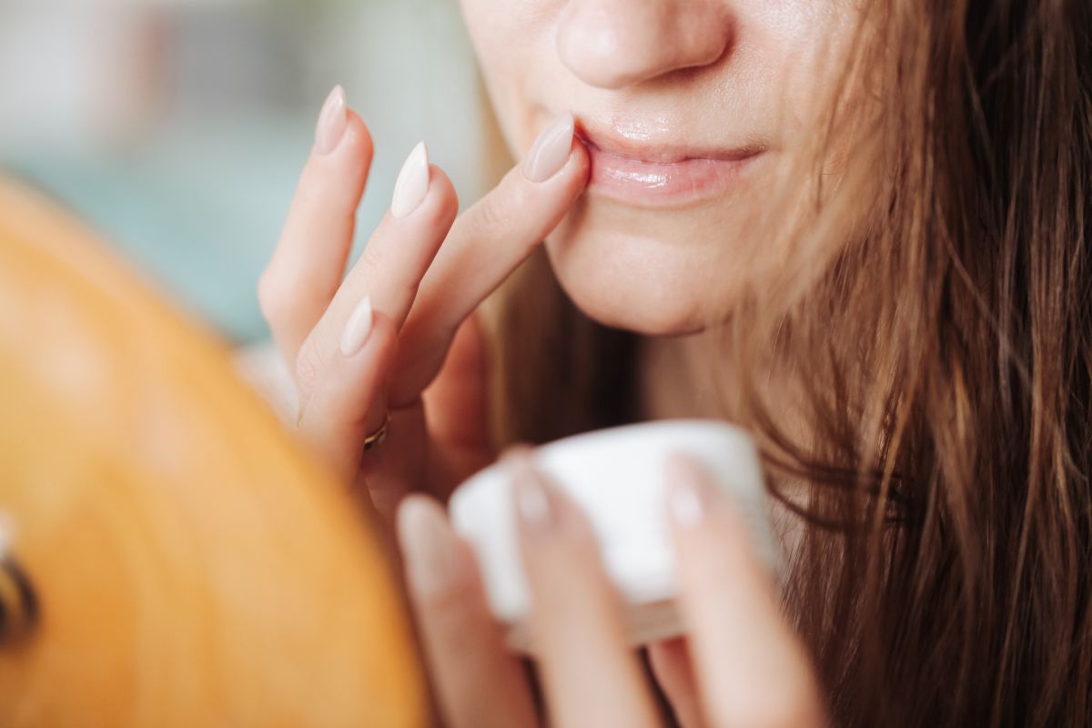 woman applies lip balm